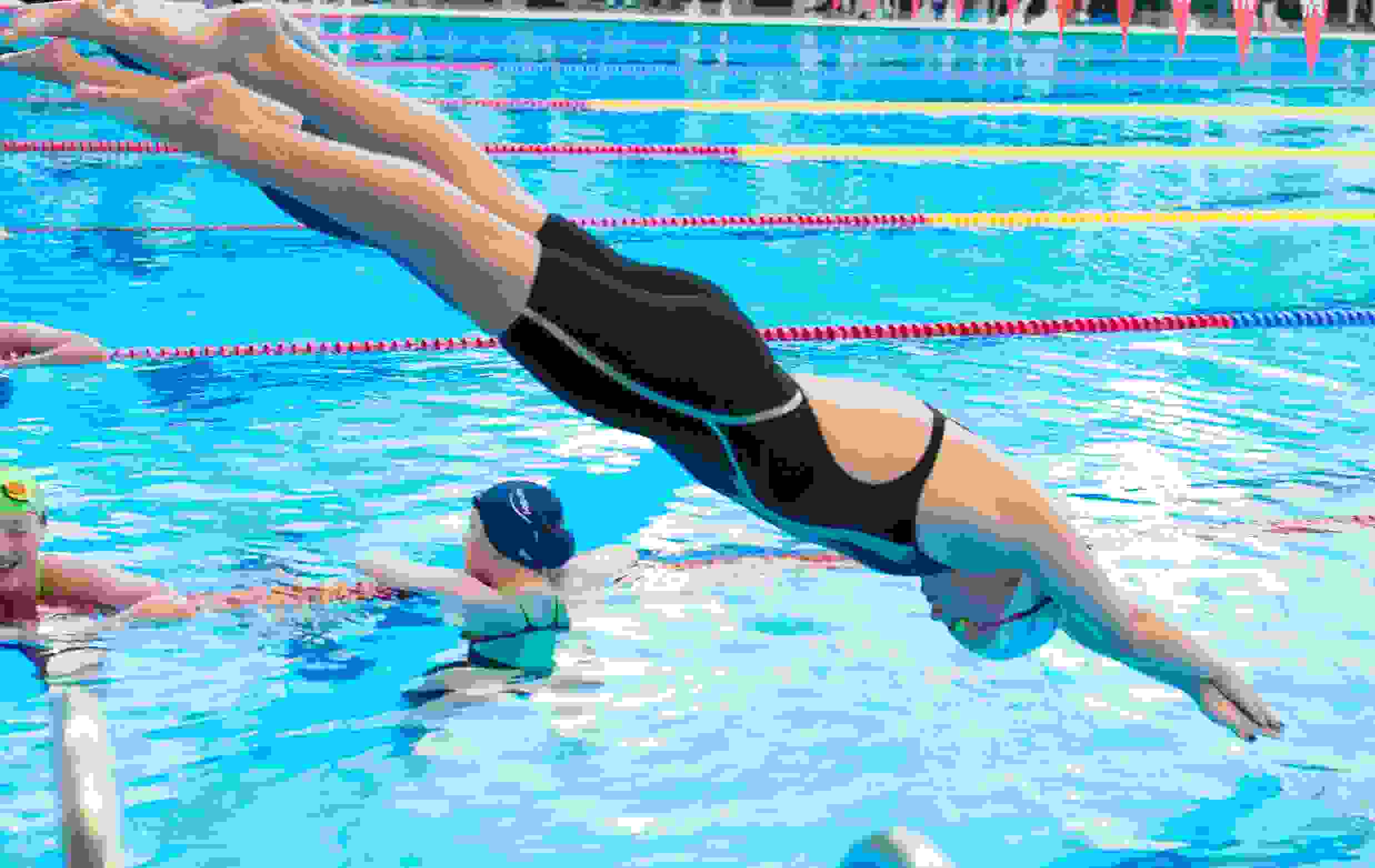 Svømmer der tager hovedspring i bassin